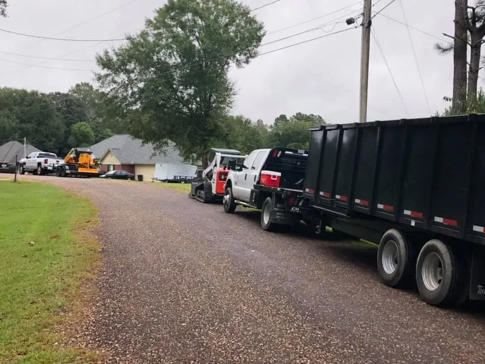 A row of trucks are parked on the side of a road.