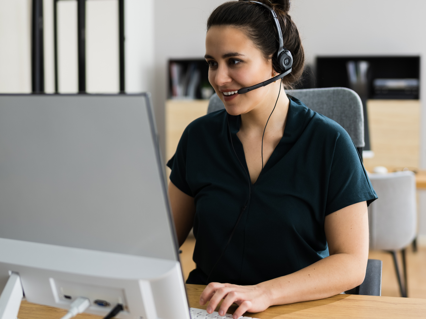 A dark haird woman works at her home office