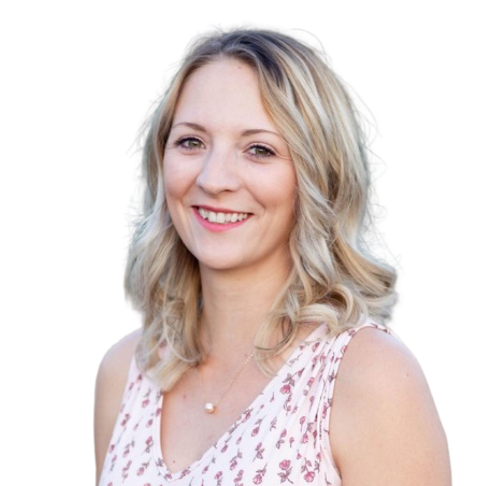 A woman in a pink tank top and necklace is smiling for the camera.