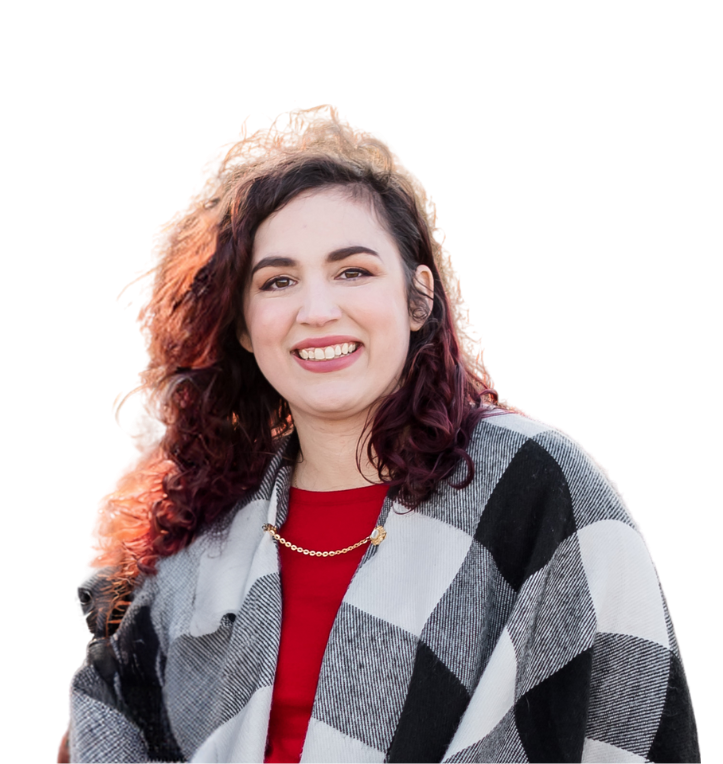 A woman wearing a plaid jacket and a red shirt is smiling.