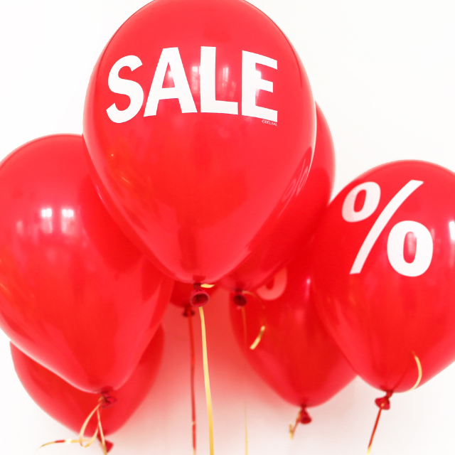 A bunch of red balloons with the word sale on them