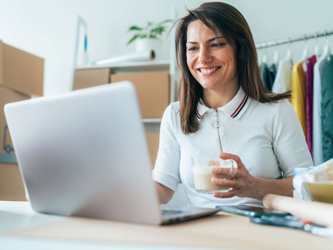 Small business owner happily receives documents on her laptop.