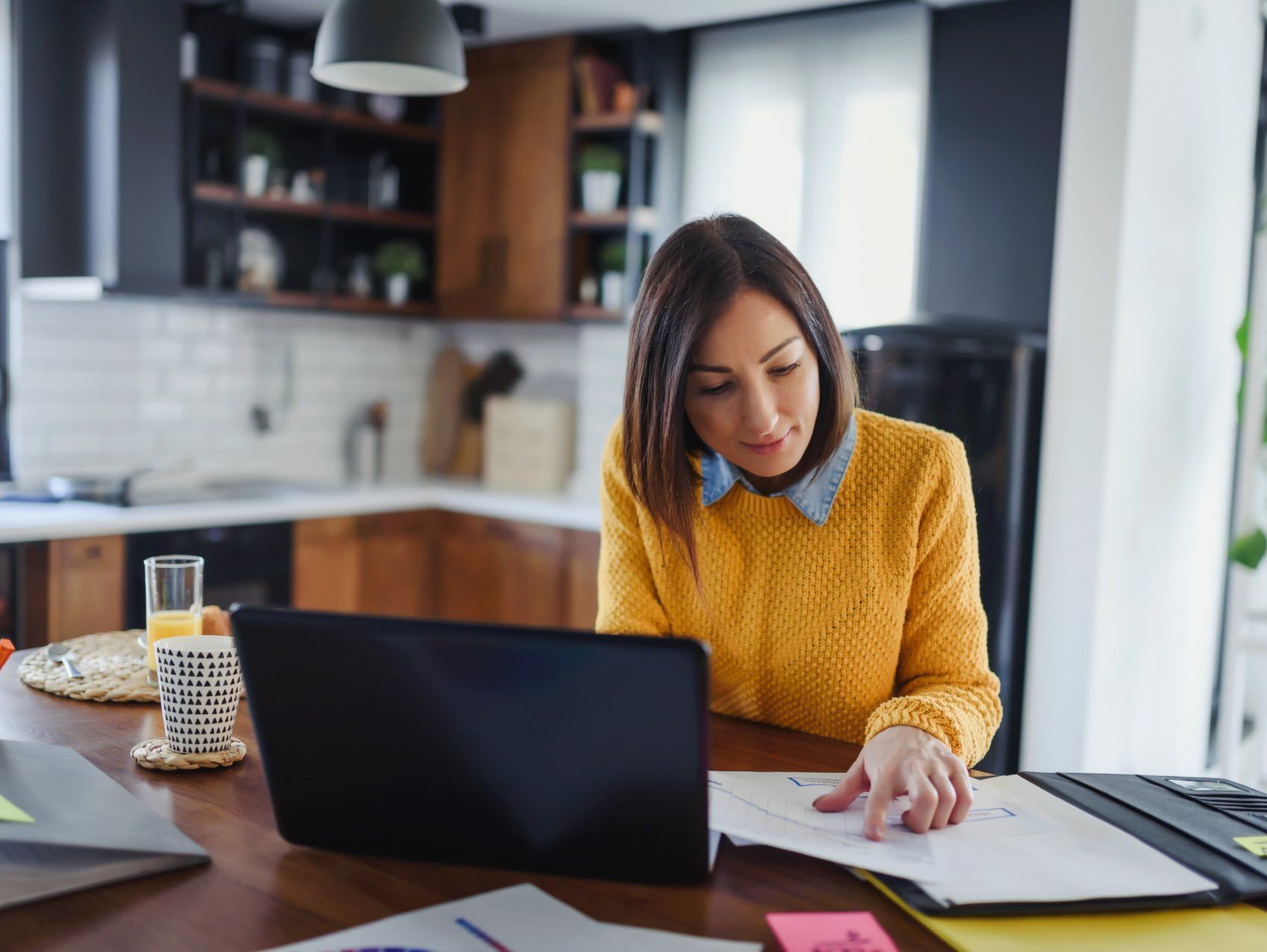 A dark haird woman works at her home office