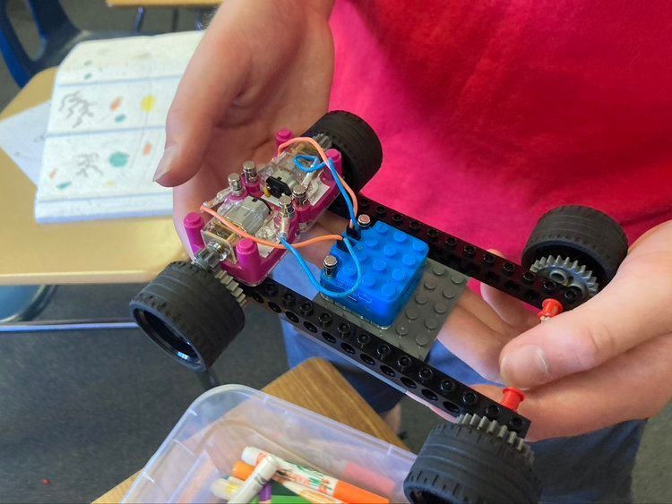 child hands hold Lego robot