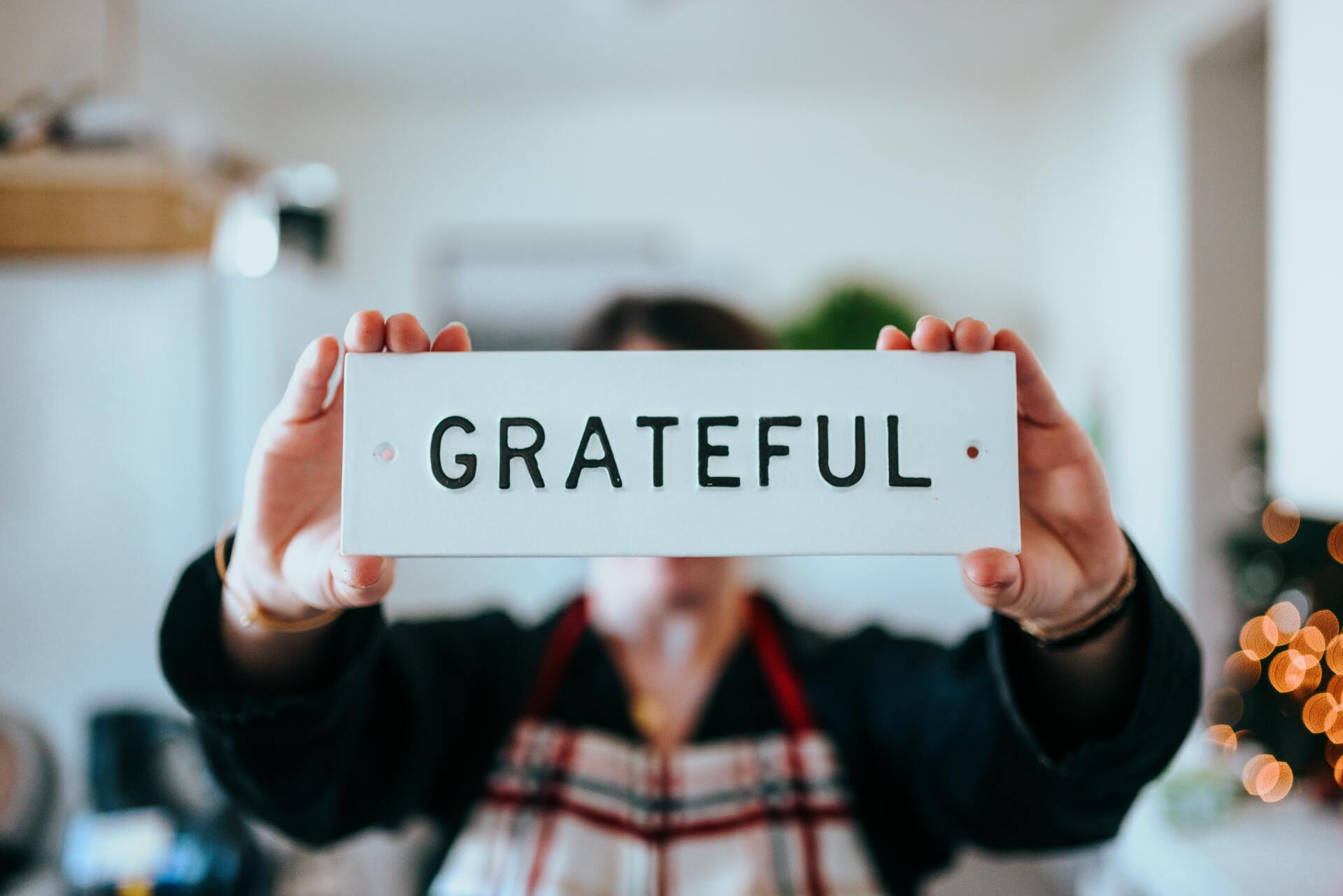 A person is holding a sign that says `` grateful '' in their hands.