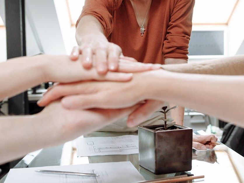 A business leader creates a handshake with teammates.