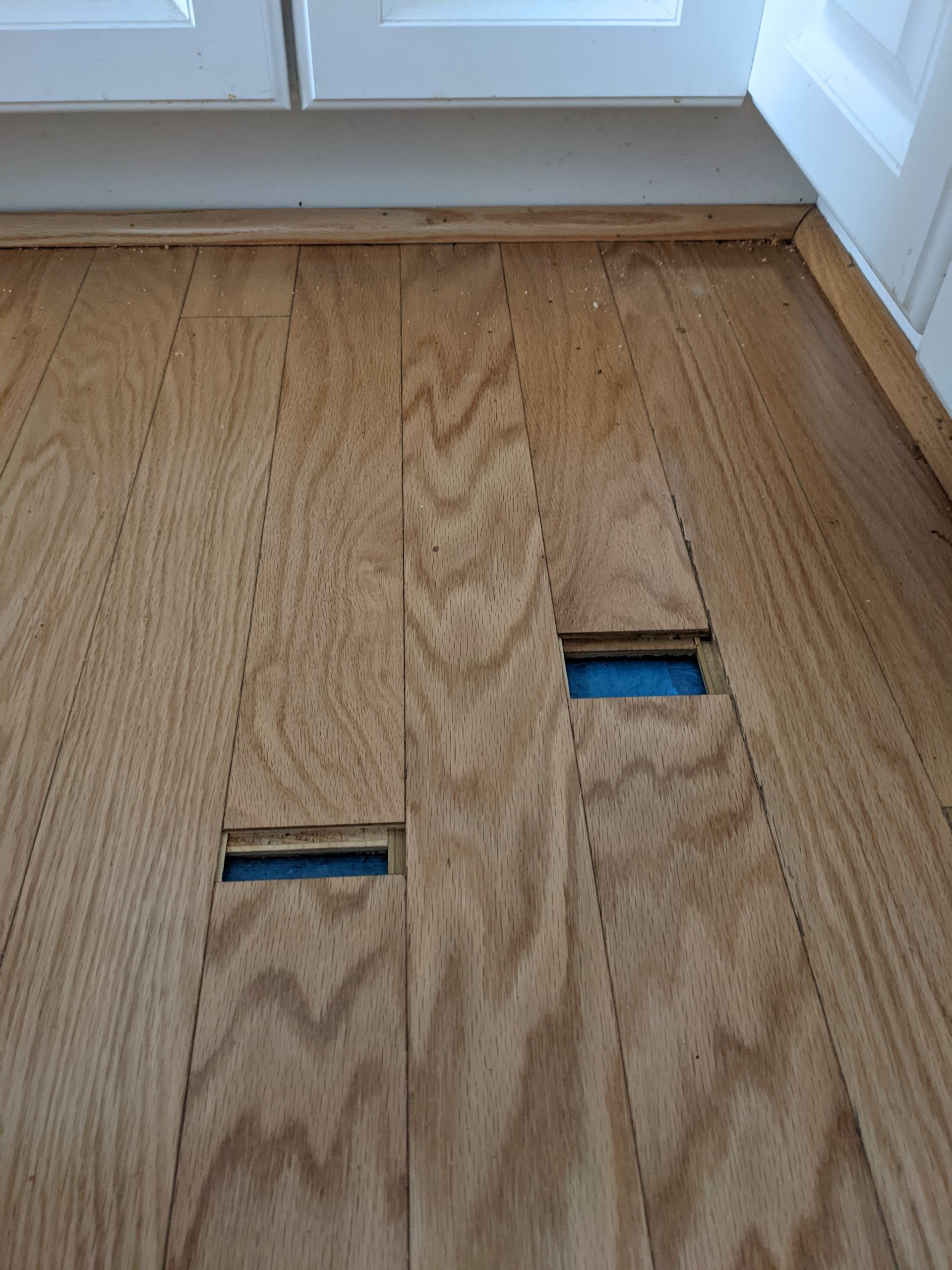 A close up of a wooden floor with holes in it.
