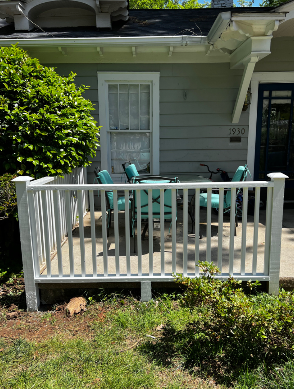There is a porch with a table and chairs on it.
