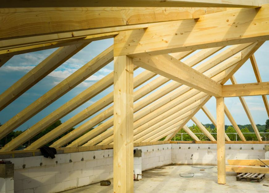 The roof of a building is being built with wooden beams.