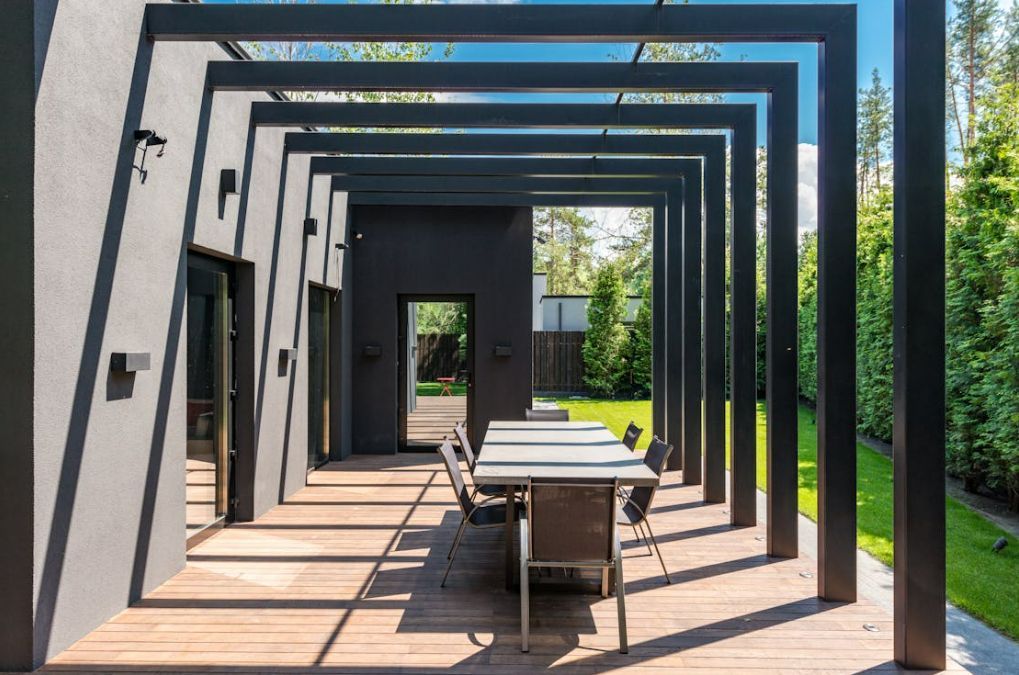 A patio with a table and chairs under a pergola.