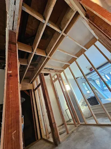 Construction framing inside a building. Wooden beams and studs create walls and ceiling structures.