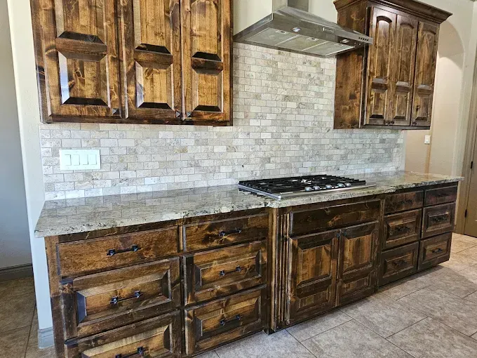 Kitchen with wooden cabinets, granite countertops, and a tiled backsplash.