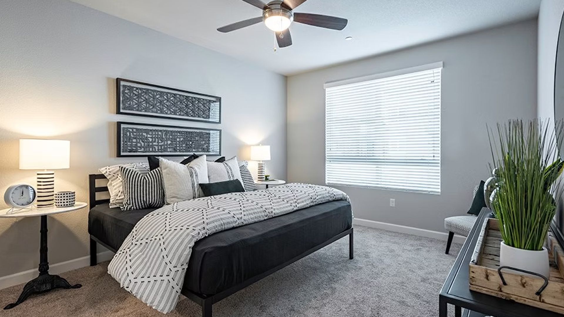 Bedroom with a black bed, side tables, artwork, and neutral color scheme.