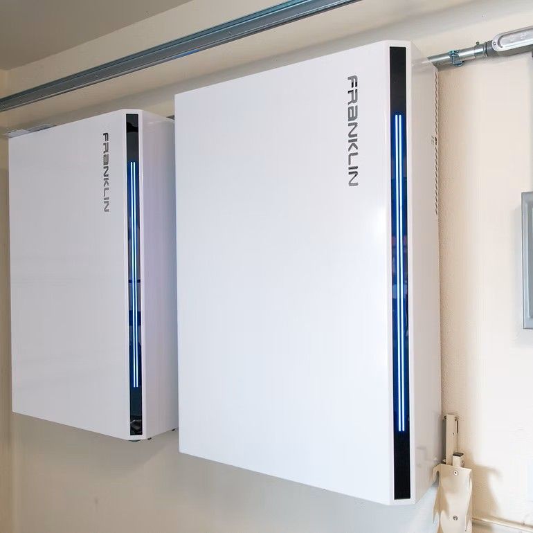 Two white Franklin energy storage units mounted on a wall with blue accent lights.