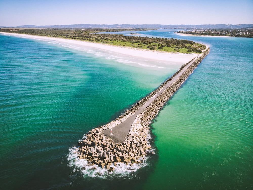 Aerial View of a Long Stone Jetty Extending From a White Sand Beach Into Turquoise Water — Superior Wifi in Ballina, NSW