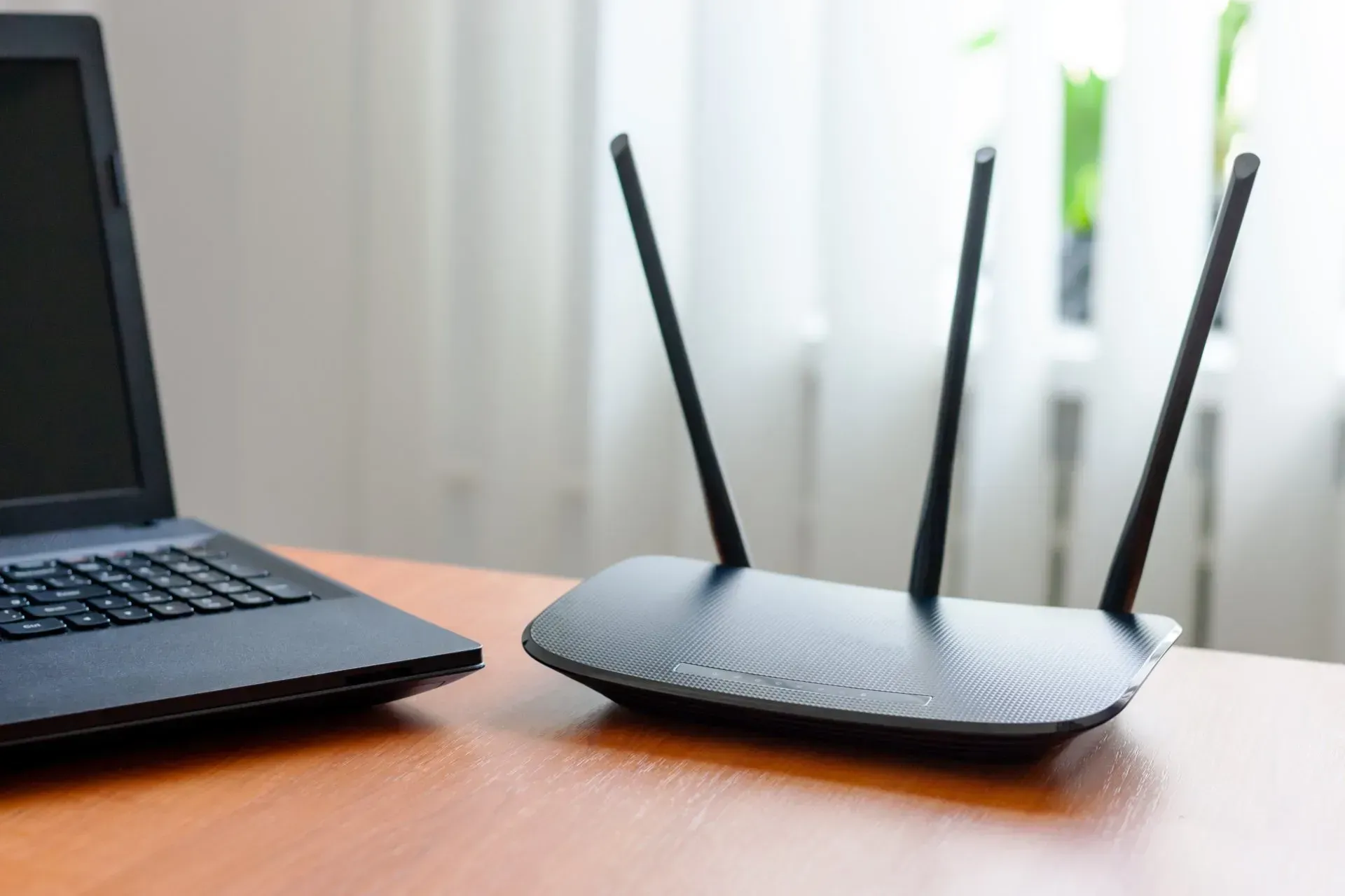 Laptop And Black Wireless Router With Three Antennas — Superior Wifi in East Ballina, NSW