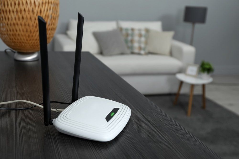 White Wifi Router With Two Black Antennas On Dark Wood Table — Superior Wifi in East Ballina, NSW