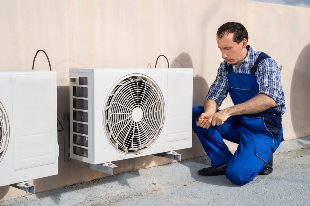Technician Installing Air-condition Outdoor Unit — Electrician in Forbes