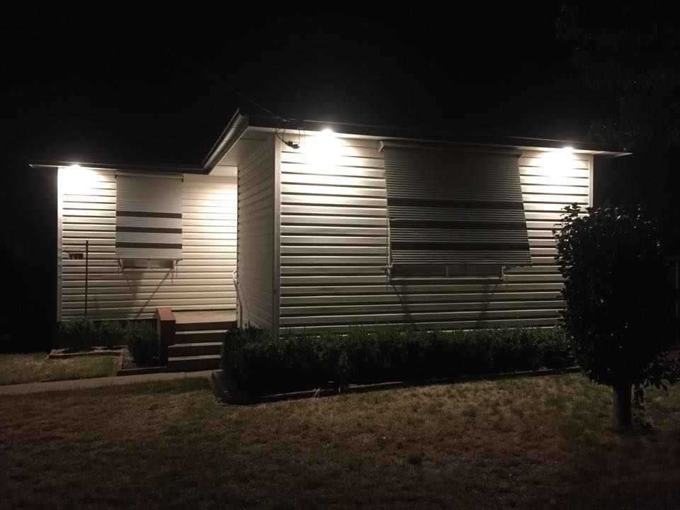 House with Lights on Outdoors at Night — Electrician in Central West