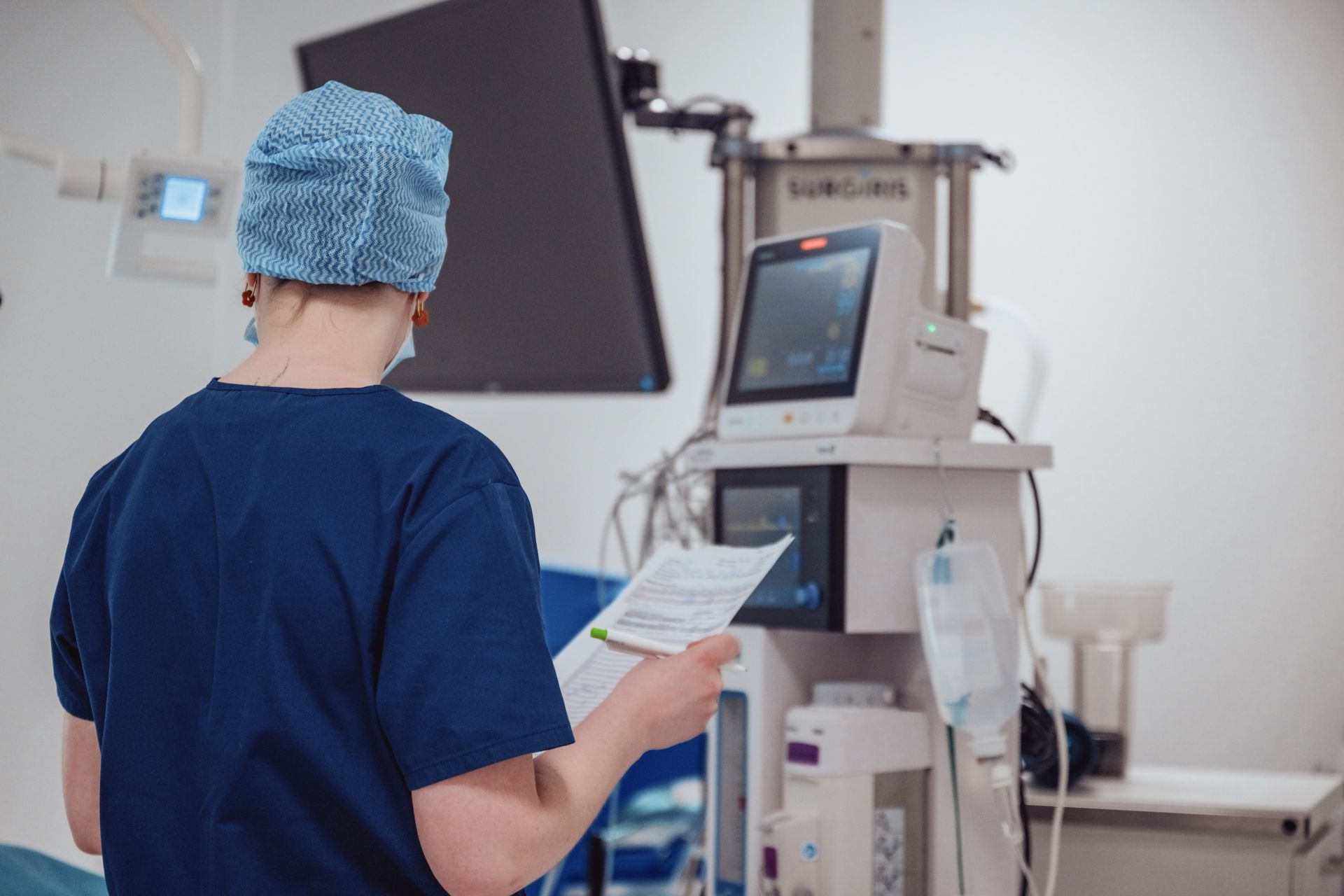 Un chirurgien regarde un morceau de papier dans une salle d'opération.