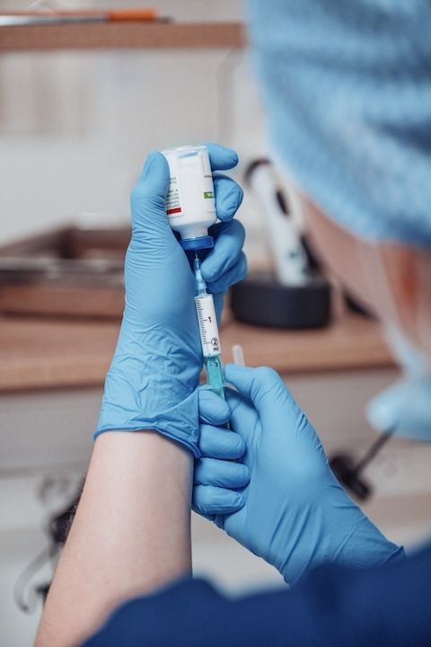 Un chirurgien prépare une injection avec une seringue.