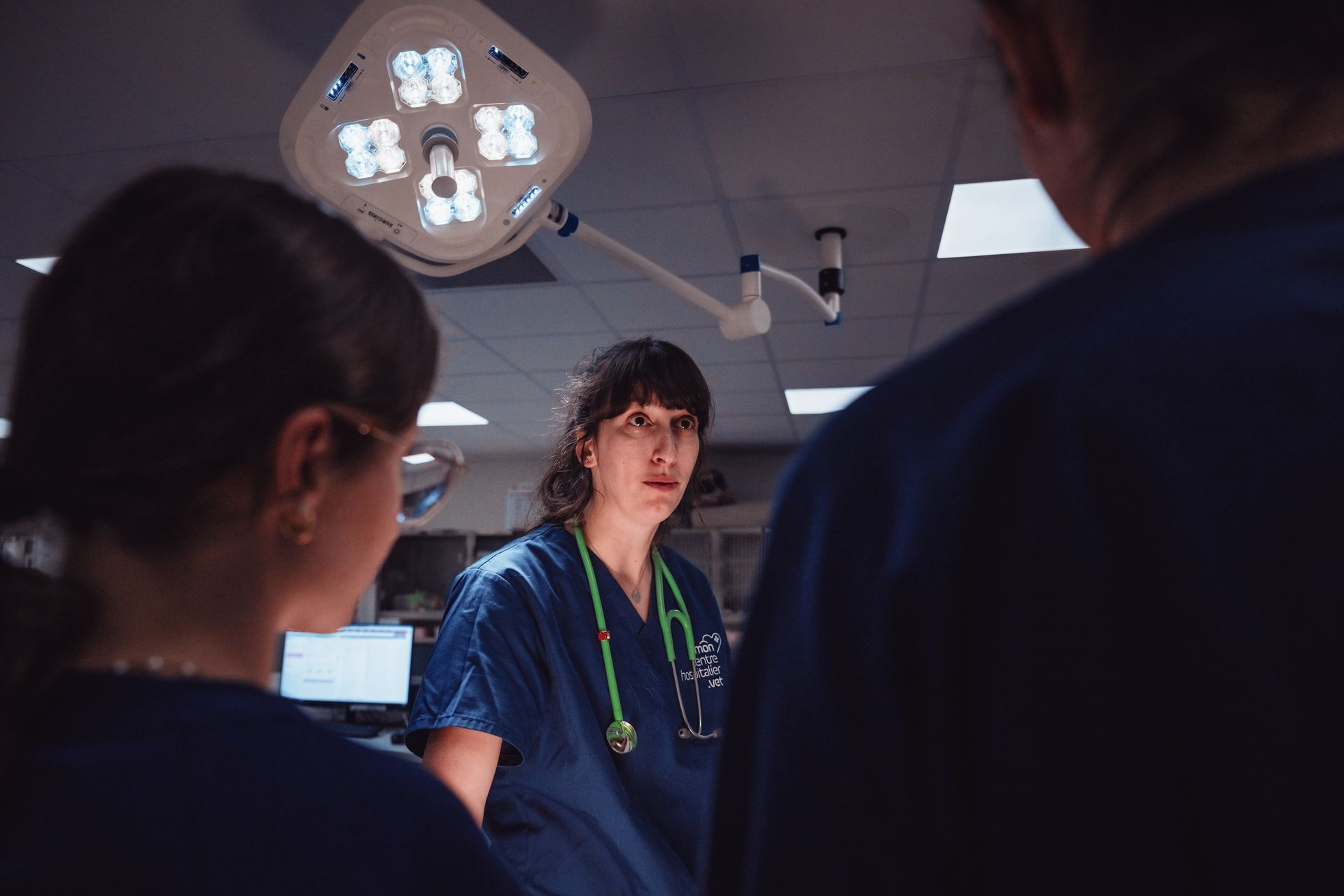 Un groupe de médecins se tient dans une salle d'opération et discute entre eux.