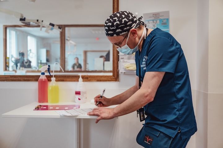 Un chirurgien écrit sur un morceau de papier dans une chambre d'hôpital.