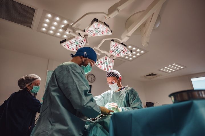 Un groupe de chirurgiens opère un patient dans une salle d'opération.