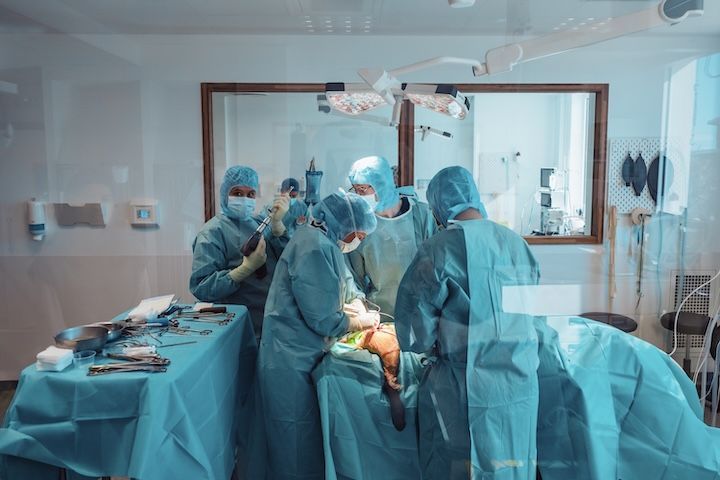 Un groupe de chirurgiens opère un patient dans une salle d'opération.