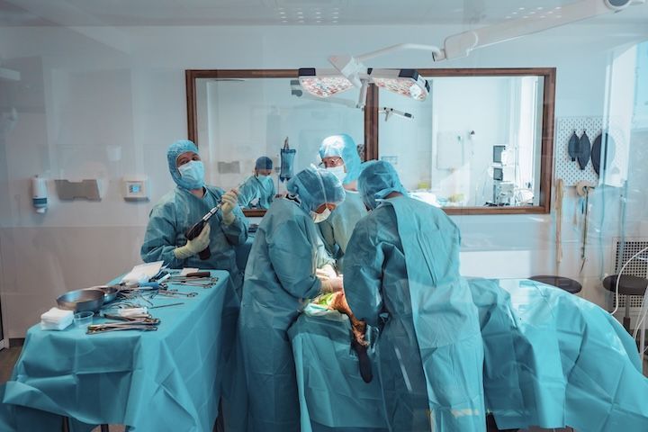Un groupe de chirurgiens effectue une intervention chirurgicale dans une salle d'opération.