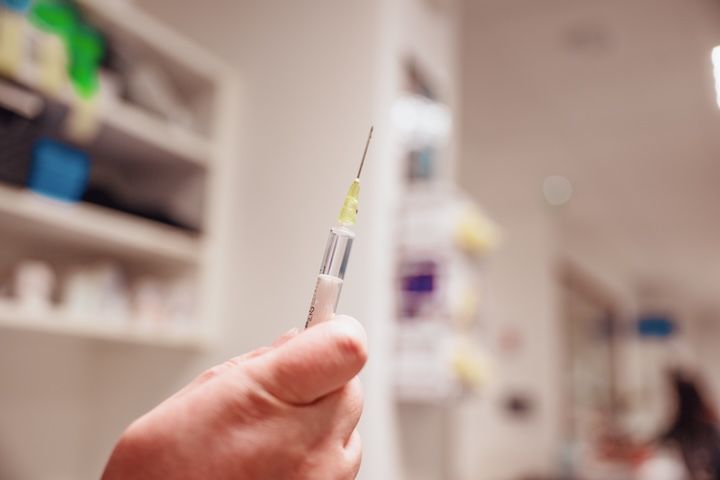Une personne tient une seringue dans sa main dans un hôpital vétérinaire