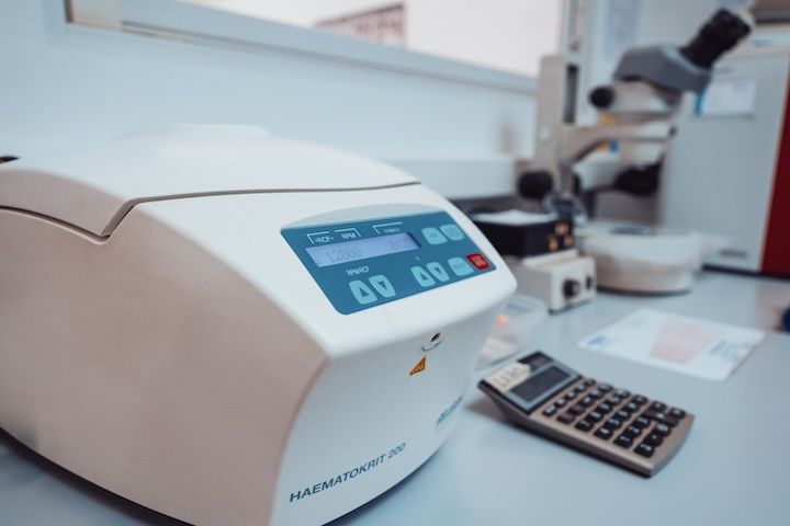 Une calculatrice est posée sur une table à côté d'une centrifugeuse.