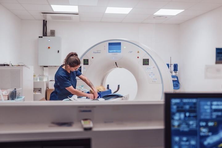 Une infirmière prépare un patient pour un scanner dans un hôpital.