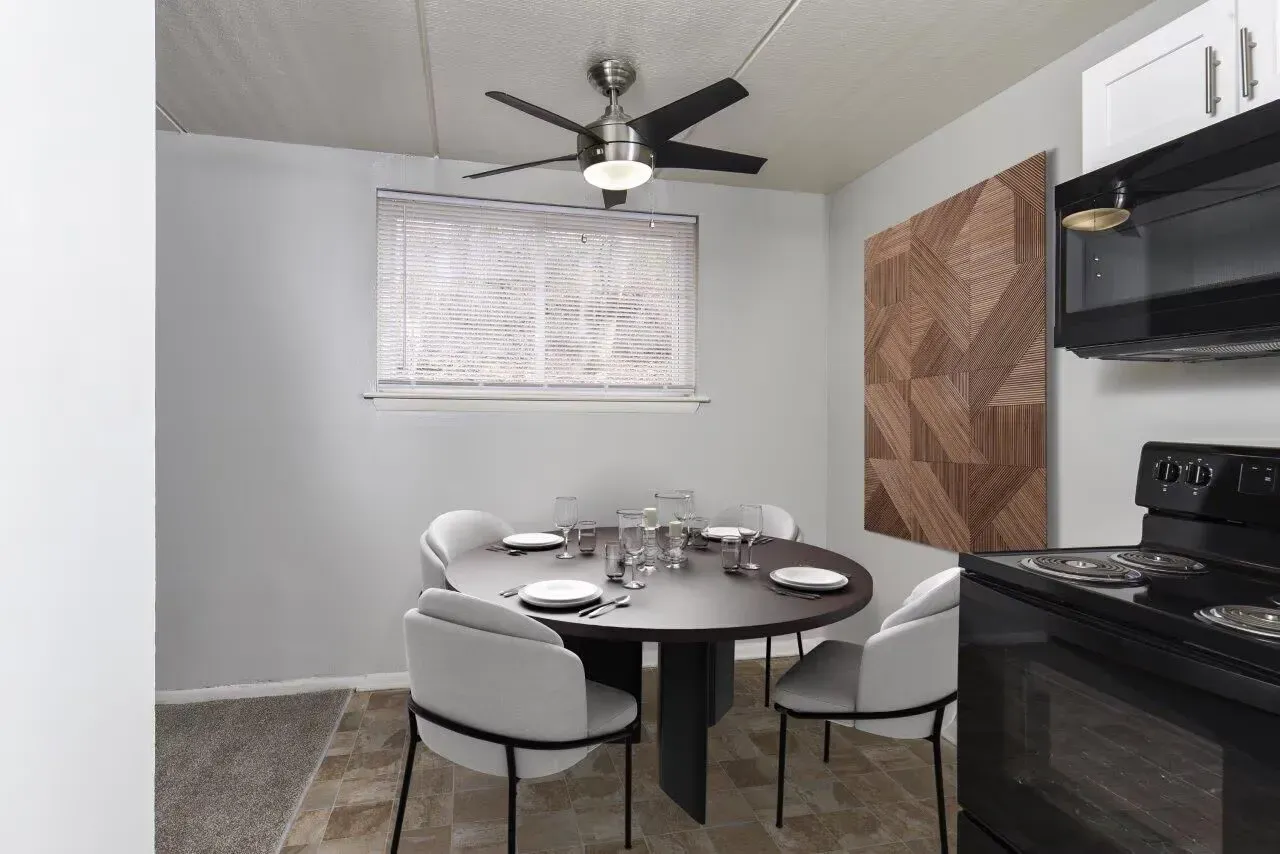 Dining area in a compact apartment kitchen with a round table and white chairs at Westover Pointe in Wilmington, DE.