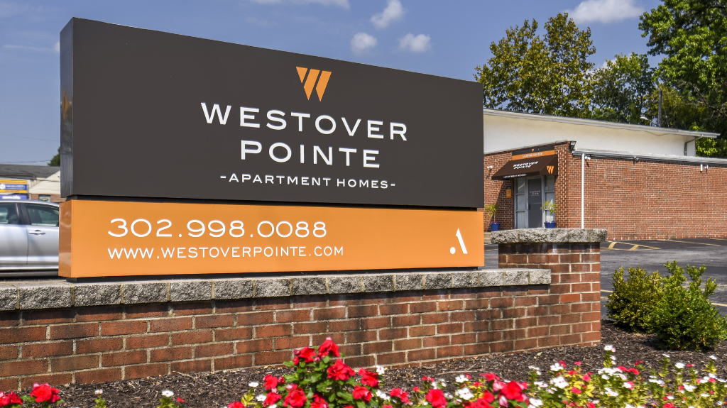 Exterior sign for Westover Pointe Apartment Homes mounted on a brick wall with landscaping at Westover Pointe in Wilmington, DE.