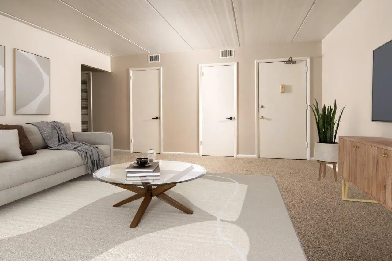 Neutral living room in an apartment with a beige sofa, coffee table, and plant at Westover Pointe in Wilmington, DE.