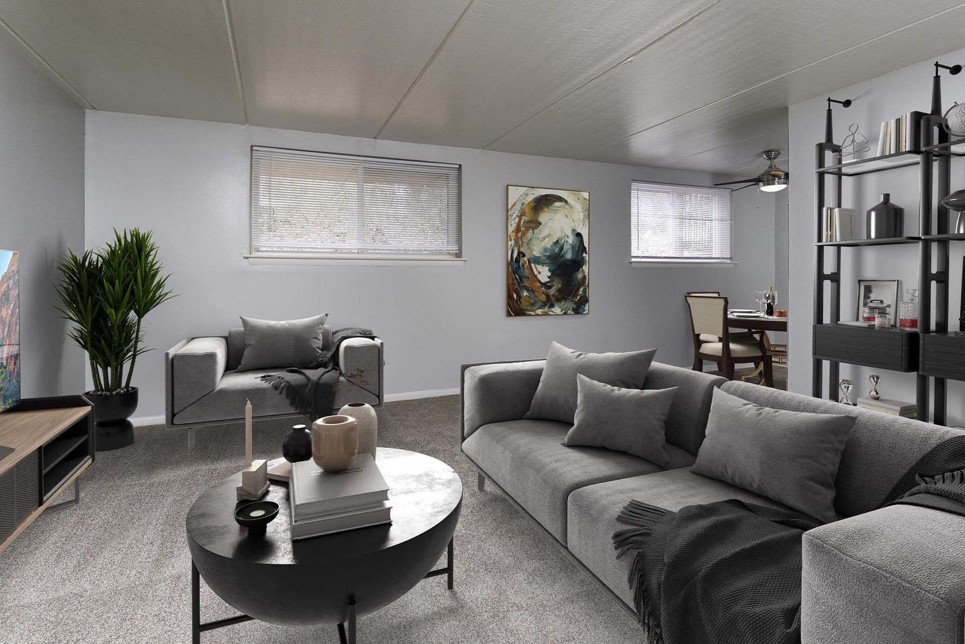 Living room in a modern apartment with gray sofas, coffee table, and decorative shelving at Westover Pointe in Wilmington, DE.