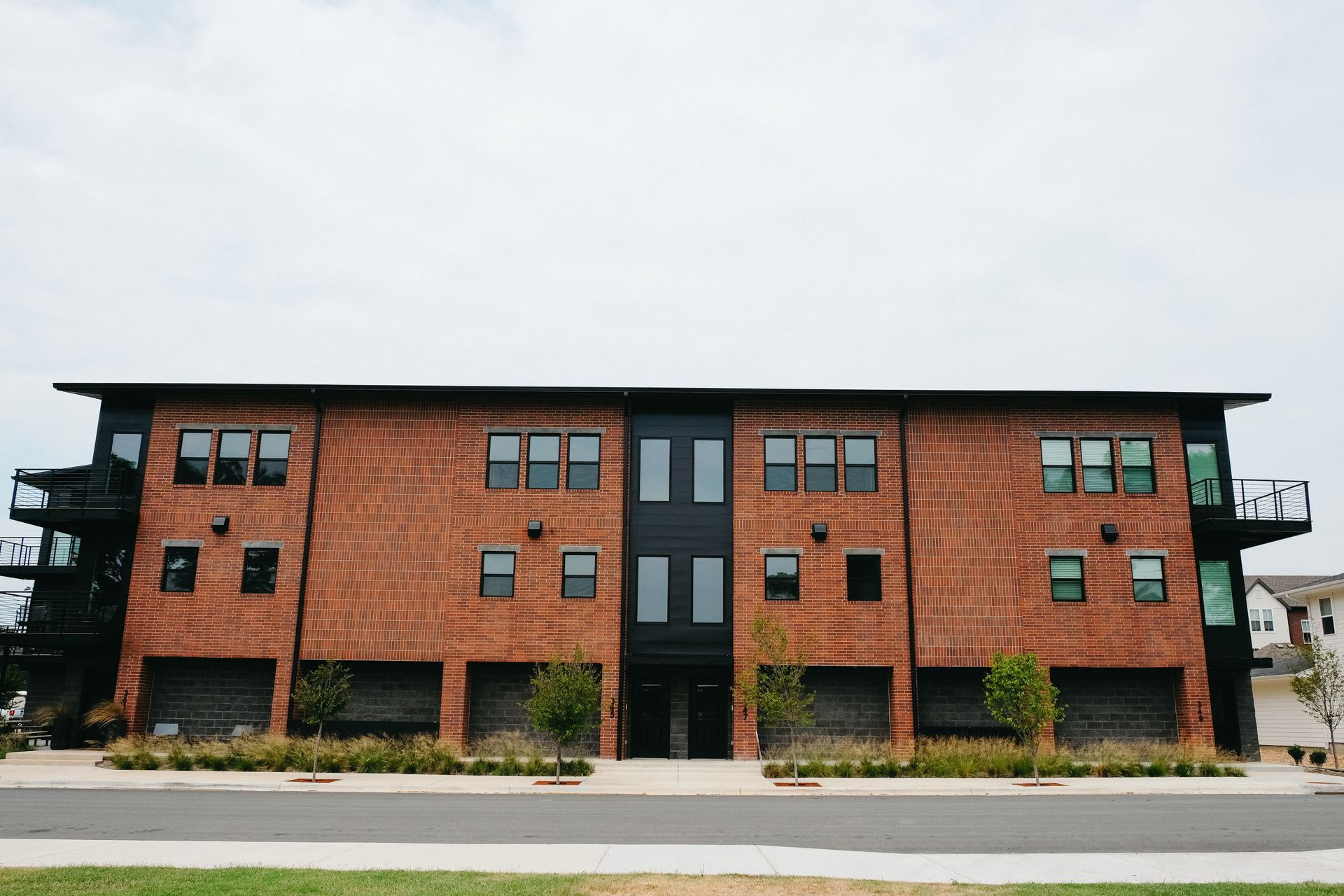 A large brick apartment building with a lot of windows and garages.