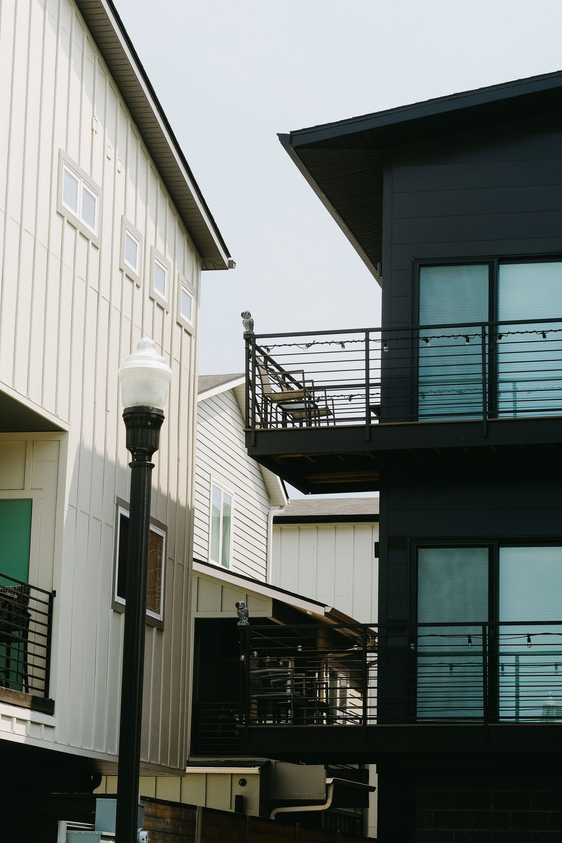 A black building with a balcony next to a white building