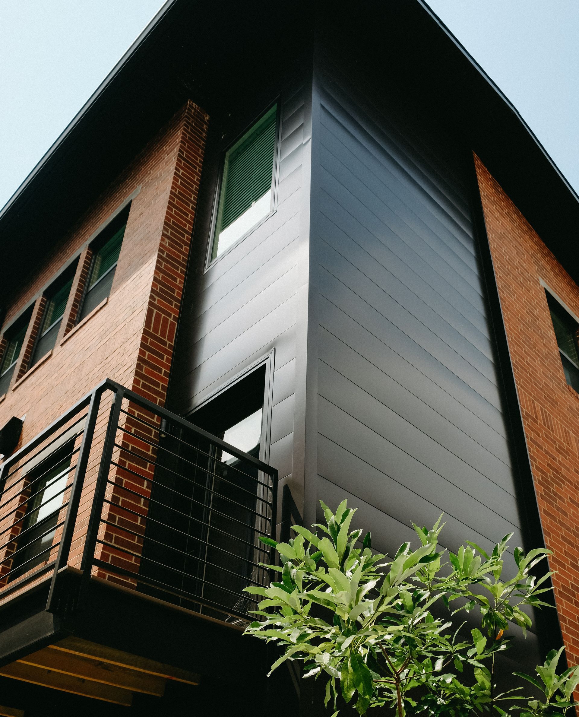 Looking up at a brick building with a balcony