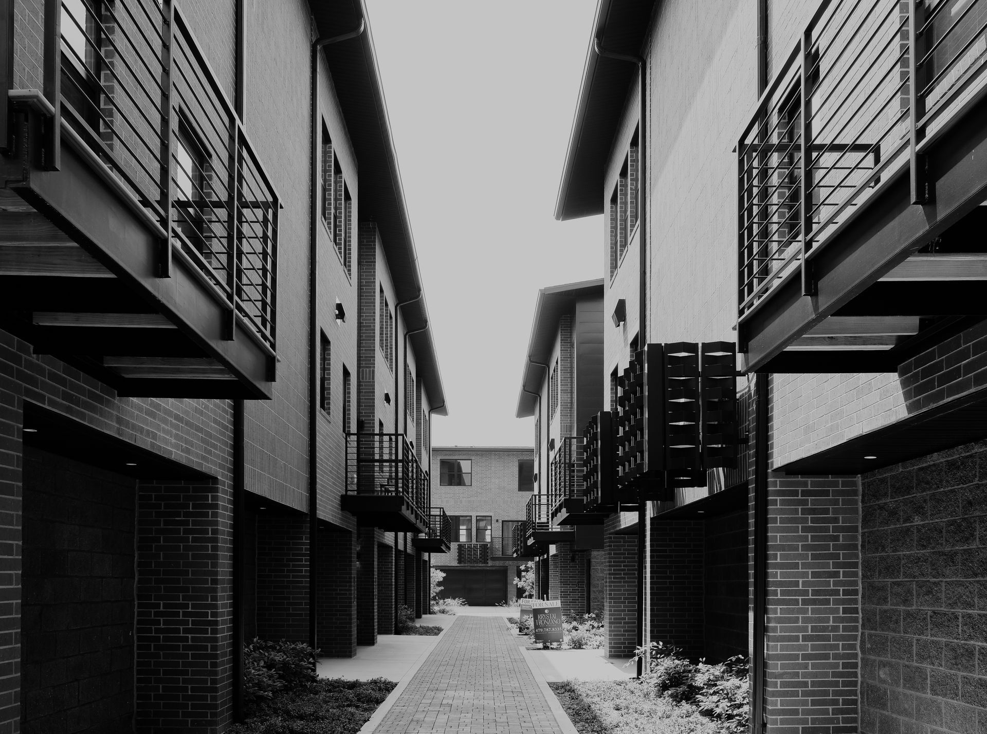 A black and white photo of a row of apartment buildings