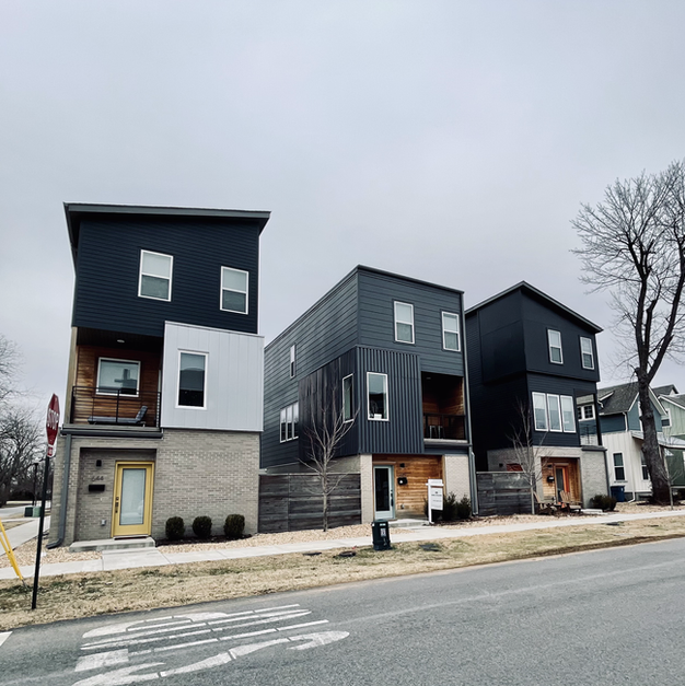 A row of houses are lined up on the side of the road