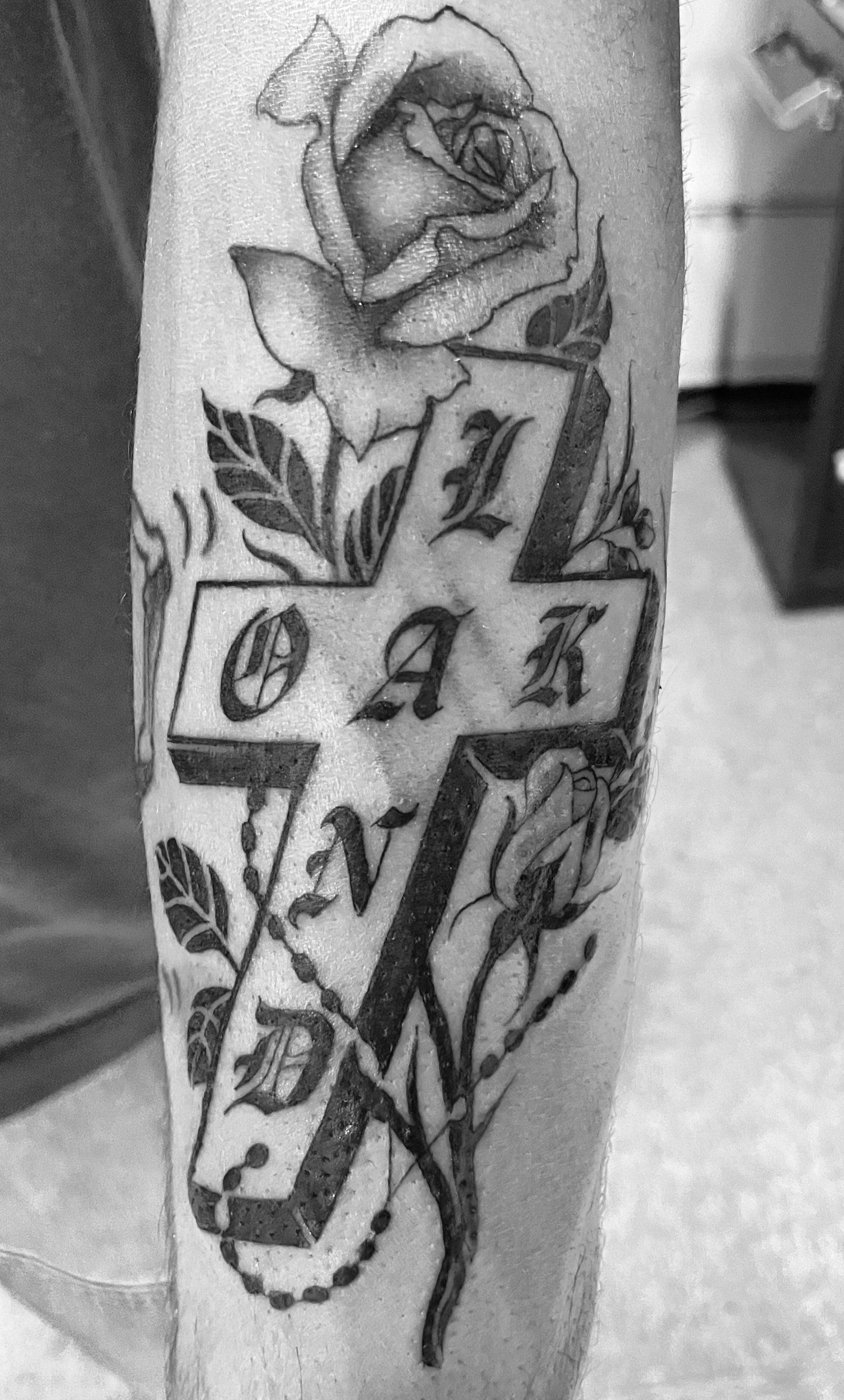 A black and white photo of a tattoo on a person 's leg.
