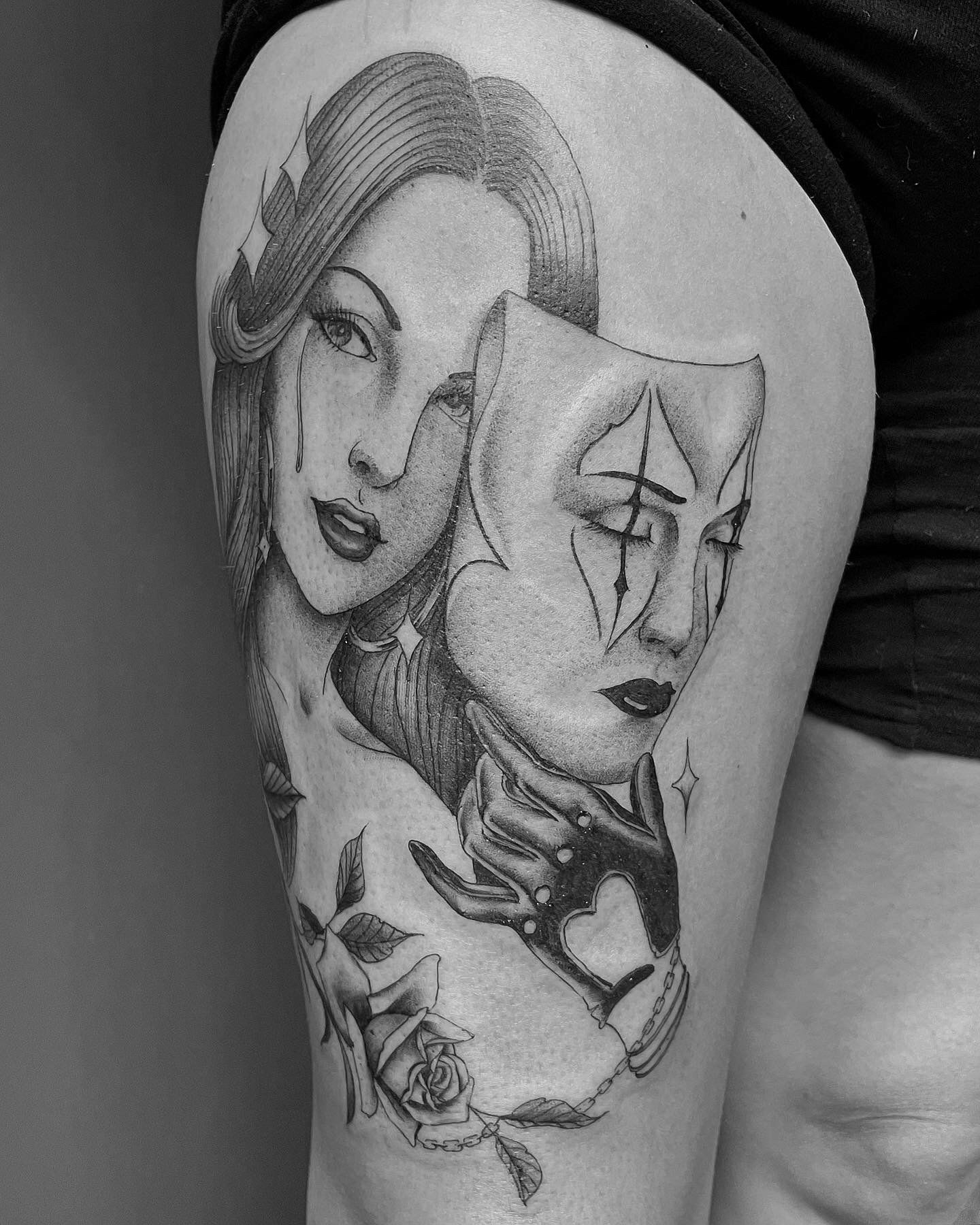 A black and white tattoo of a woman with a mask on her thigh.