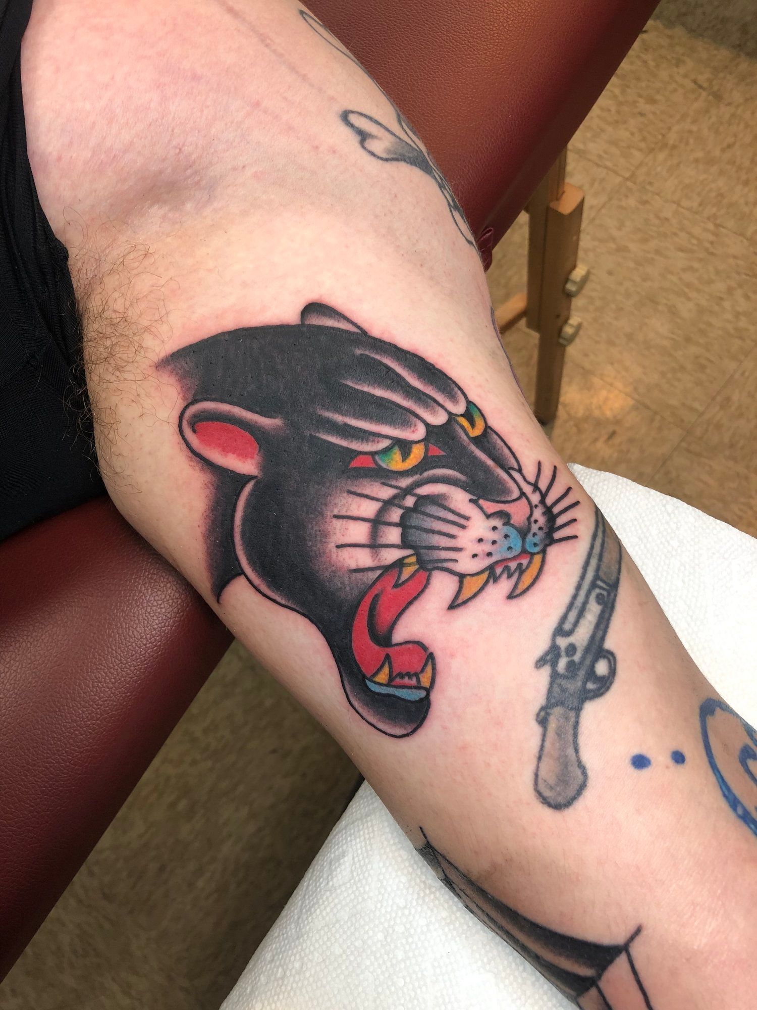A person has a panther tattoo on their arm