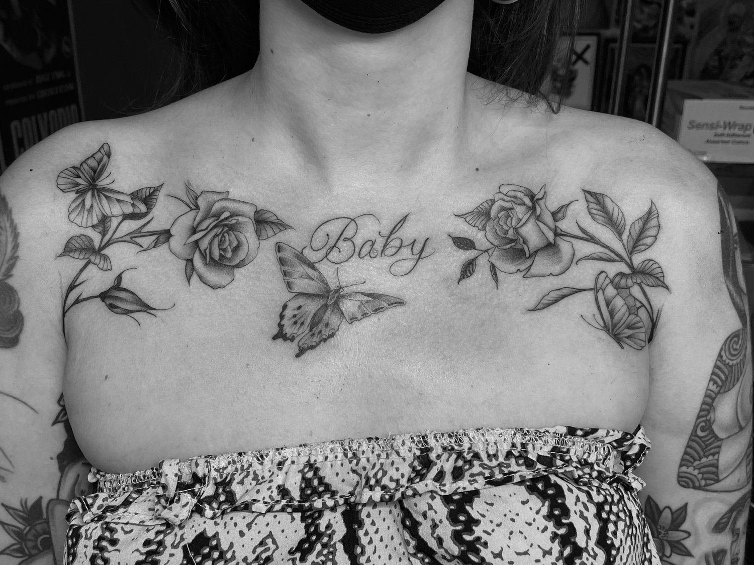 A woman has a tattoo on her chest that says baby
