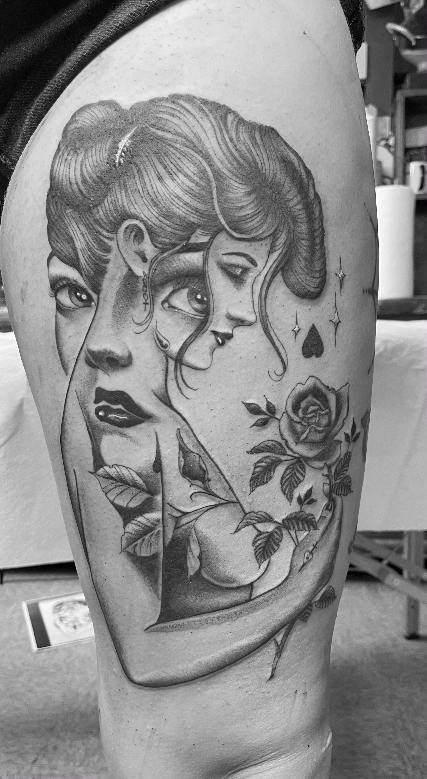 A black and white photo of a tattoo on a woman 's leg.