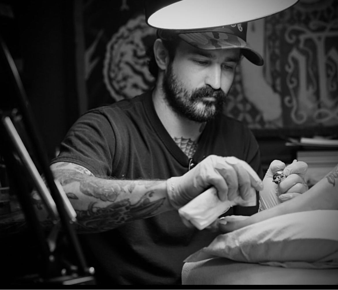 A person has a tattoo of a rattlesnake on their leg.