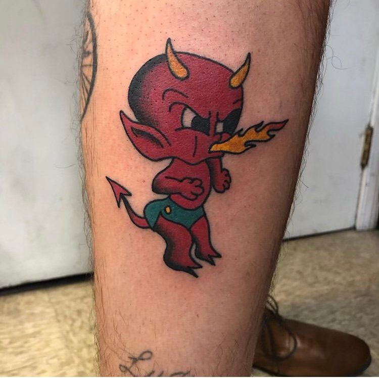 A tattoo of a little red devil with horns and a tail