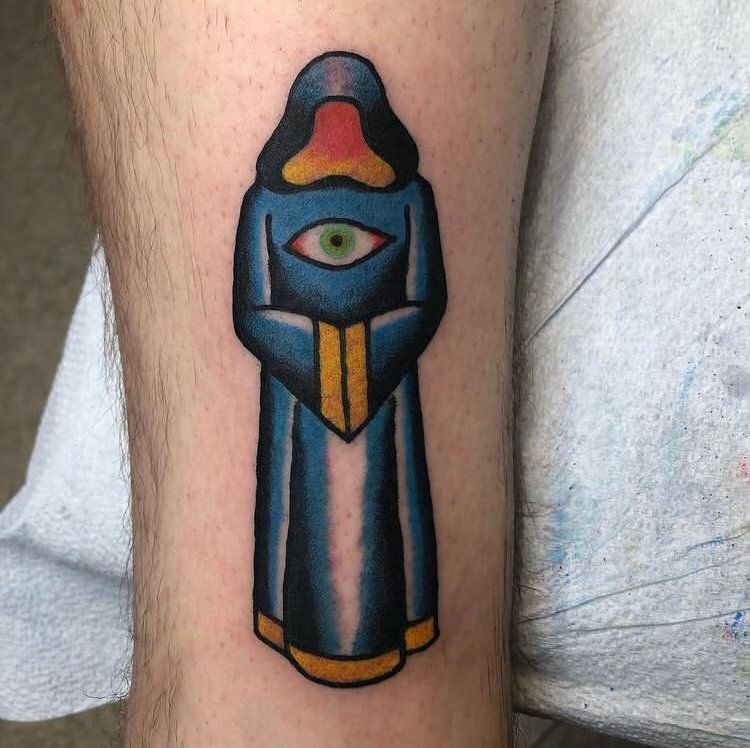 A person has a tattoo of a person with an eye on their leg